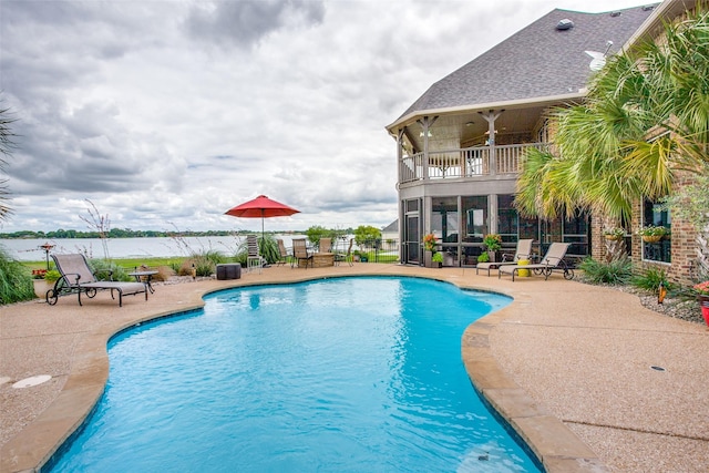 view of swimming pool with a patio and a water view