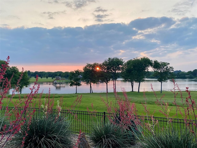 yard at dusk featuring a rural view and a water view