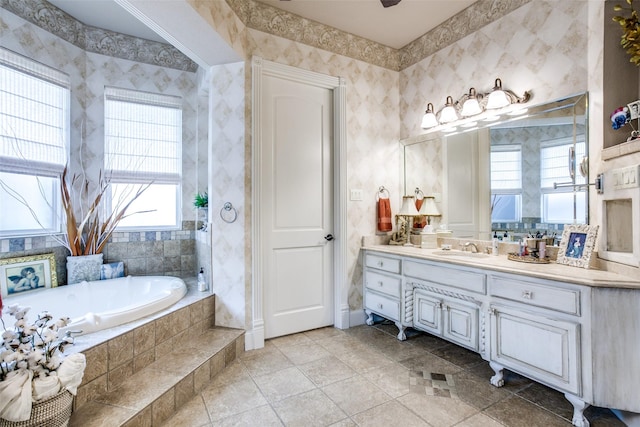 bathroom with tiled bath, tile patterned flooring, vanity, and a healthy amount of sunlight