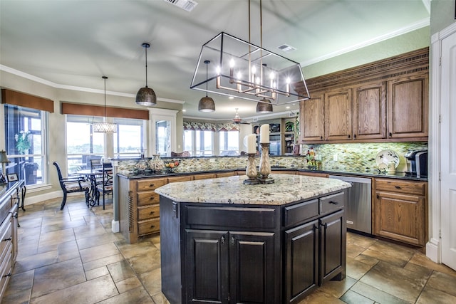 kitchen with a kitchen island, hanging light fixtures, stainless steel dishwasher, and crown molding