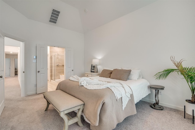 carpeted bedroom featuring connected bathroom and lofted ceiling