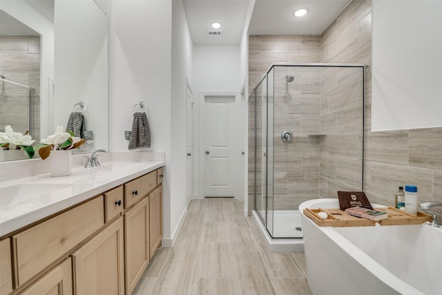 bathroom with vanity, hardwood / wood-style floors, and plus walk in shower