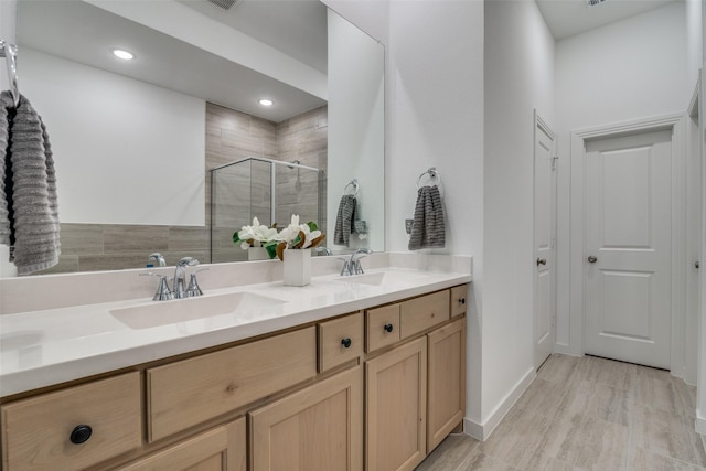 bathroom with hardwood / wood-style floors, vanity, and walk in shower