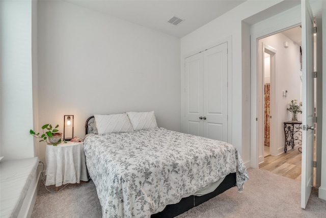 bedroom featuring light colored carpet and a closet