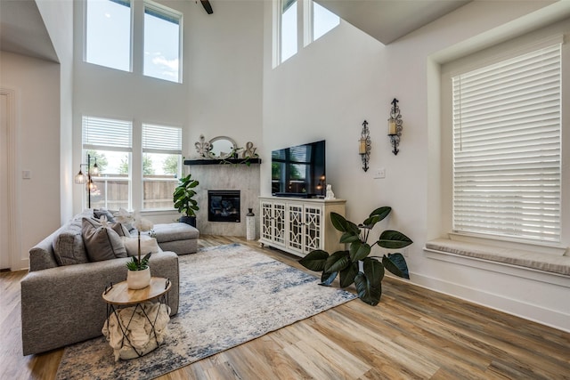 1145 Queensdown Way, Forney, TX 75126 - living area with a fireplace, wood finished floors, a towering ceiling, and baseboards