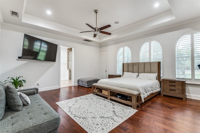 bedroom with ceiling fan, dark hardwood / wood-style flooring, crown molding, and a tray ceiling