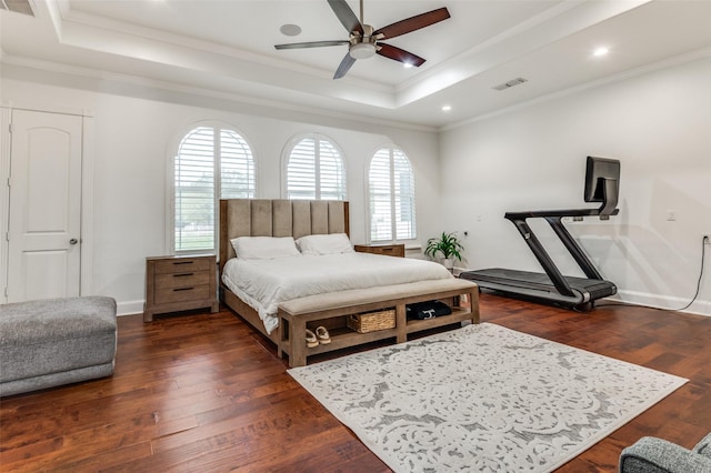 bedroom featuring dark hardwood / wood-style floors, a tray ceiling, and crown molding