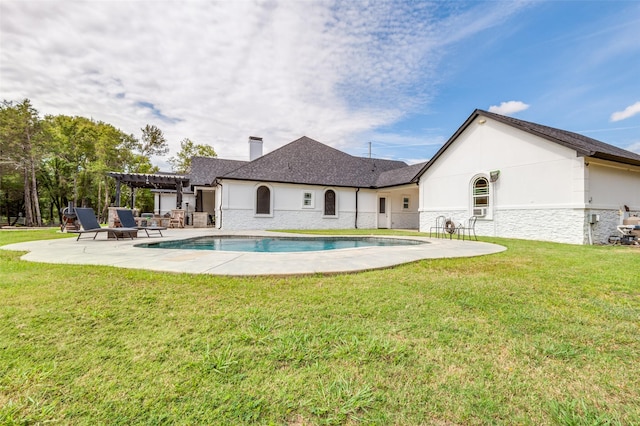 rear view of house with a lawn and a patio