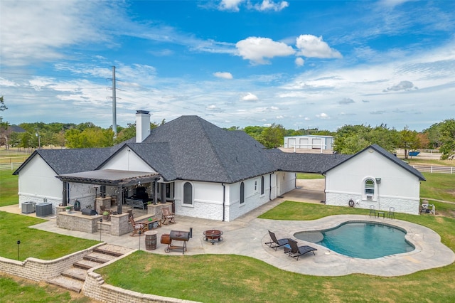 back of property featuring central AC, a patio, an outdoor kitchen, and an outdoor fire pit