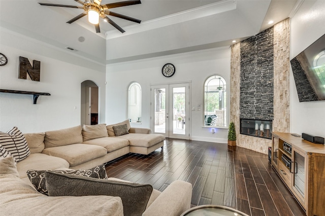 living room featuring french doors, a towering ceiling, ornamental molding, and dark hardwood / wood-style floors