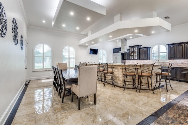 dining room with crown molding and a towering ceiling