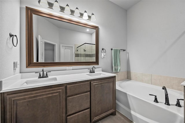 bathroom with independent shower and bath, vanity, and tile patterned flooring