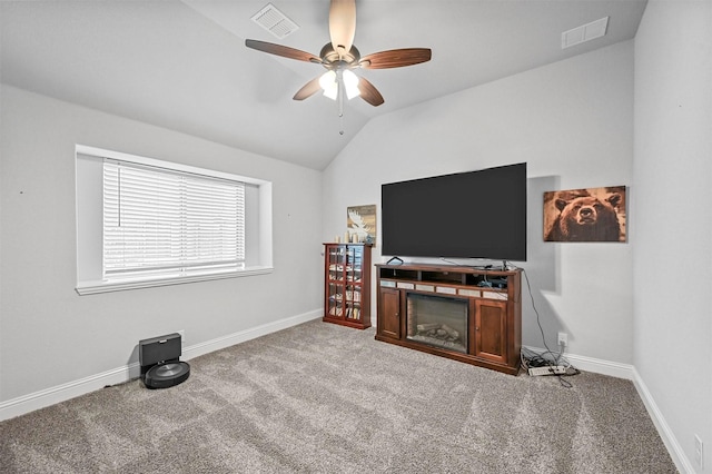 interior space featuring ceiling fan, vaulted ceiling, and light carpet