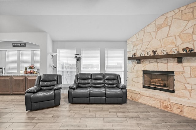 living room featuring vaulted ceiling and a fireplace