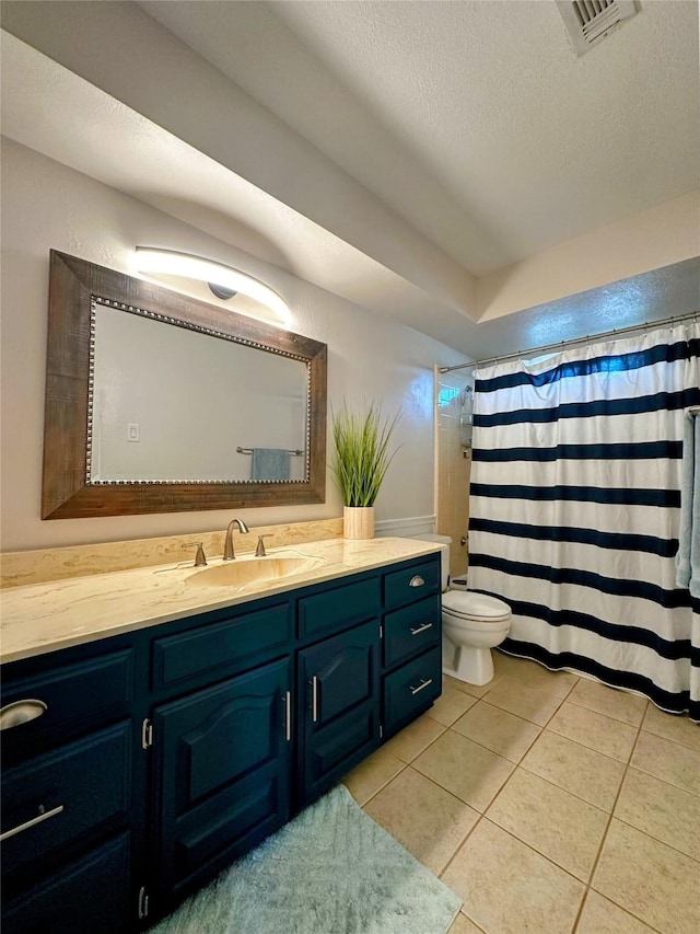 bathroom with tile patterned floors, vanity, toilet, and a textured ceiling