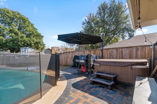 view of patio / terrace featuring a swimming pool with hot tub