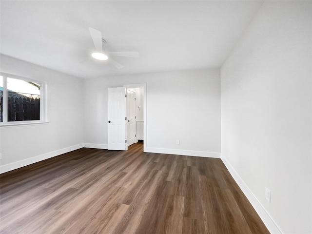 empty room with ceiling fan and dark hardwood / wood-style flooring