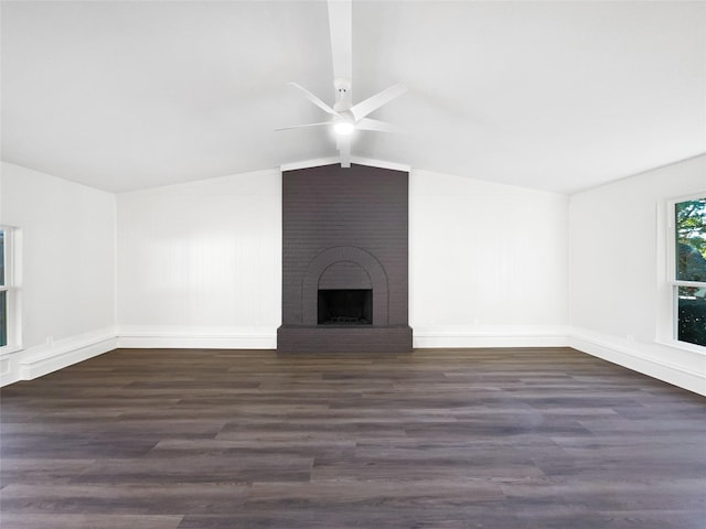 unfurnished living room with ceiling fan, dark hardwood / wood-style floors, a brick fireplace, and vaulted ceiling with beams