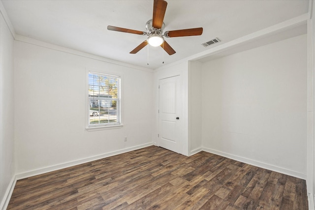 spare room with dark hardwood / wood-style floors, ceiling fan, and ornamental molding