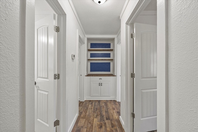 hall with dark wood-type flooring and a textured ceiling