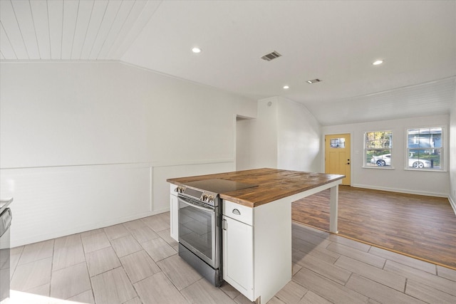 kitchen with light hardwood / wood-style flooring, butcher block countertops, vaulted ceiling, white cabinets, and appliances with stainless steel finishes