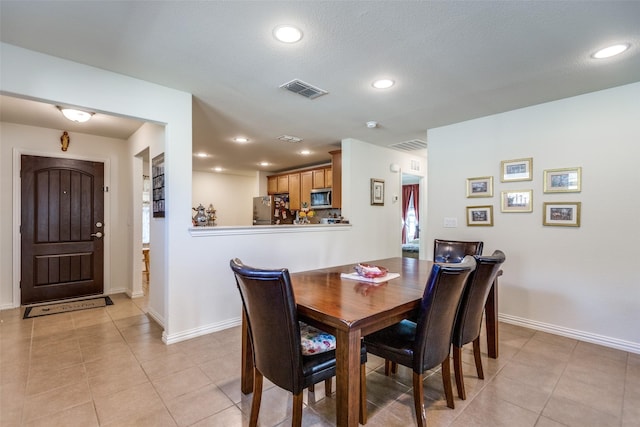 dining area with ceiling fan, light tile patterned floors, and a textured ceiling