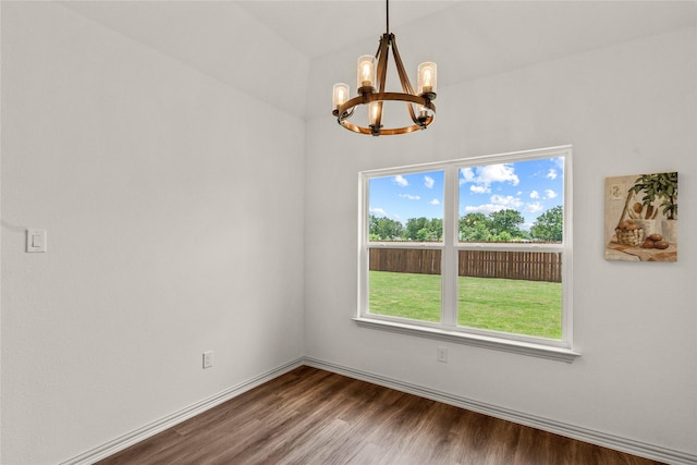 unfurnished room featuring a notable chandelier, wood-type flooring, and vaulted ceiling