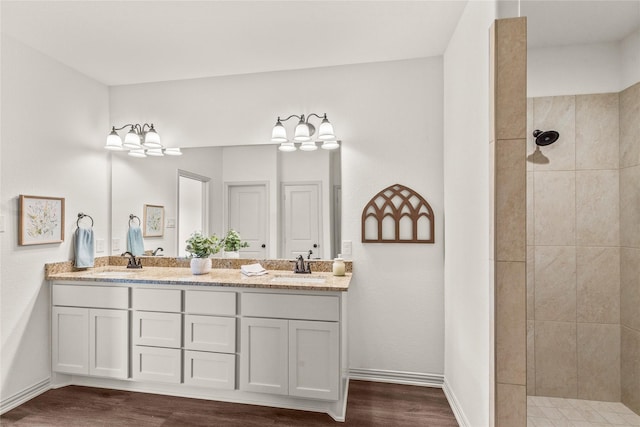 bathroom featuring a tile shower, vanity, and hardwood / wood-style flooring