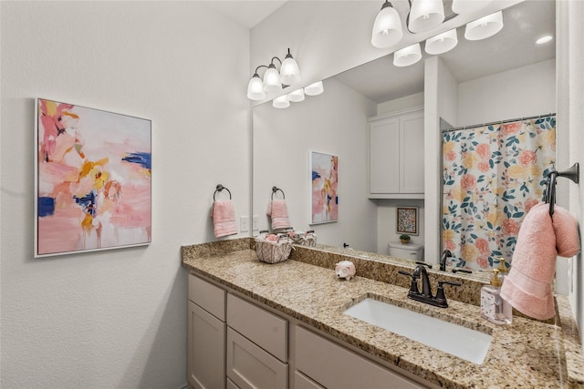 bathroom featuring vanity, an inviting chandelier, and toilet