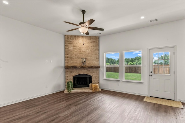 unfurnished living room featuring a fireplace, wood-type flooring, and ceiling fan