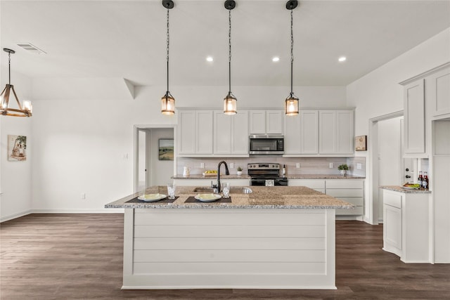 kitchen with a kitchen island with sink, sink, dark hardwood / wood-style floors, decorative light fixtures, and stainless steel appliances