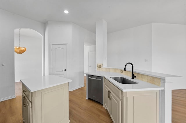 kitchen featuring sink, dishwasher, hanging light fixtures, and cream cabinetry