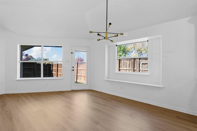 unfurnished living room featuring light hardwood / wood-style floors and a chandelier