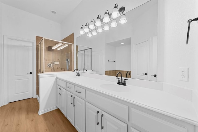 bathroom with hardwood / wood-style flooring, walk in shower, and vanity