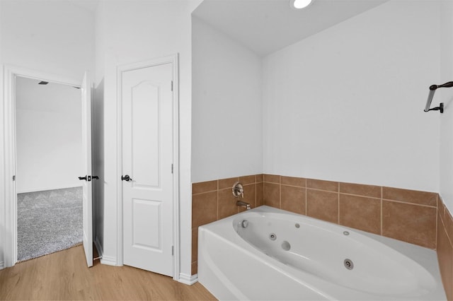 bathroom featuring hardwood / wood-style flooring and a bath