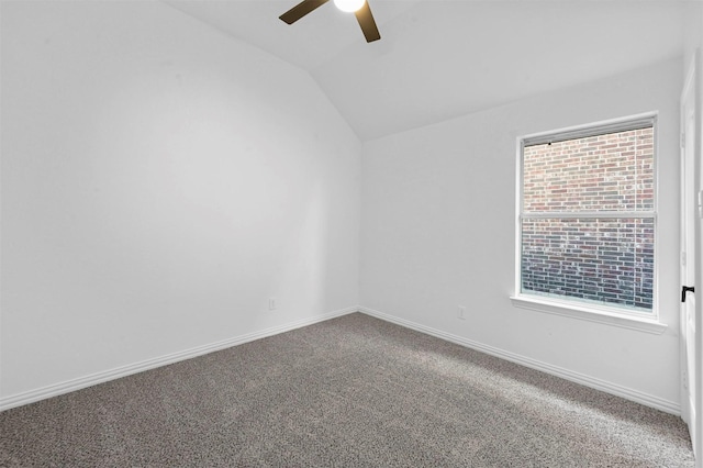 carpeted empty room featuring ceiling fan, a wealth of natural light, and lofted ceiling