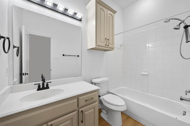 full bathroom with vanity, toilet, tiled shower / bath, and hardwood / wood-style floors