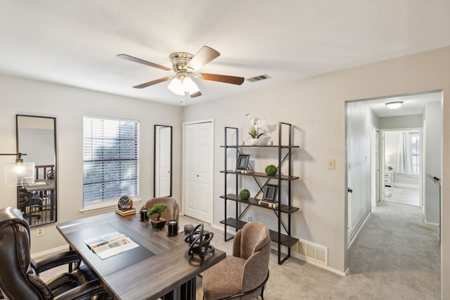 carpeted home office featuring ceiling fan