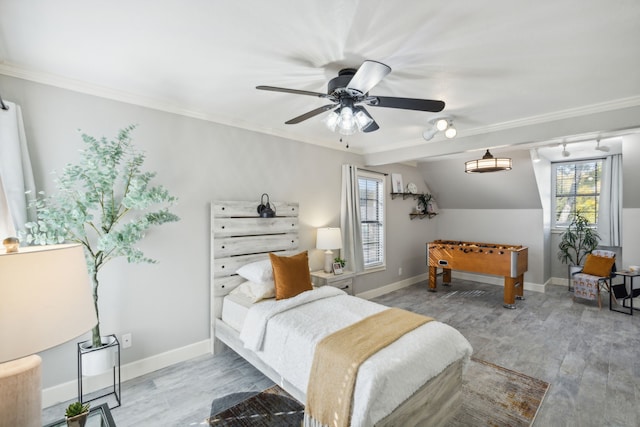 bedroom featuring ceiling fan, light wood-type flooring, ornamental molding, and vaulted ceiling