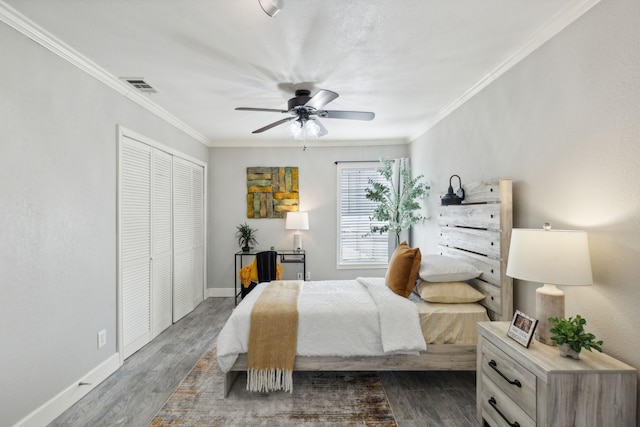 bedroom featuring ceiling fan, a closet, dark hardwood / wood-style floors, and ornamental molding