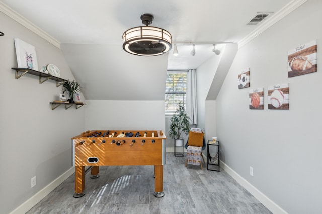 game room with rail lighting, wood-type flooring, lofted ceiling, and ornamental molding