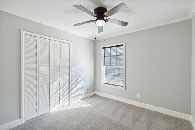 unfurnished bedroom with a closet, ceiling fan, crown molding, and light carpet