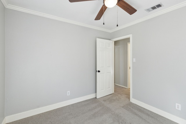 carpeted spare room featuring ceiling fan and ornamental molding