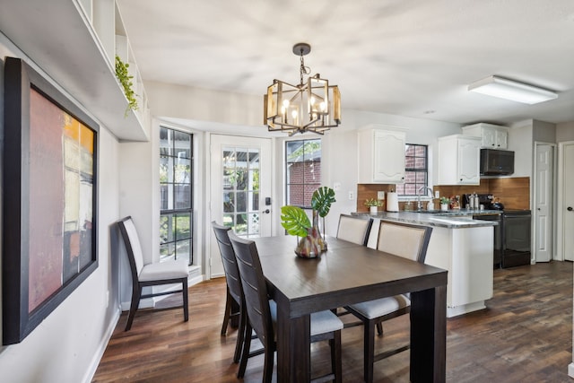 dining room featuring dark hardwood / wood-style flooring, a chandelier, and sink