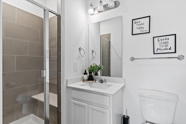 bathroom featuring vanity, toilet, and an enclosed shower