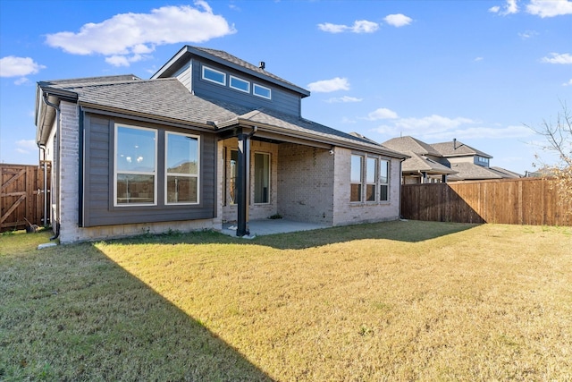 rear view of property featuring a yard and a patio