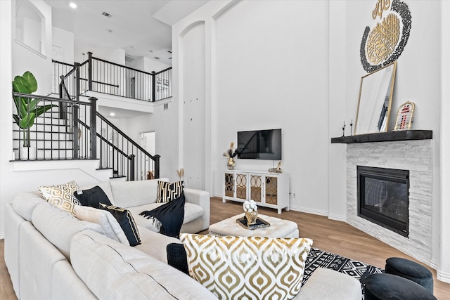 1307 Wheelwright Dr, Forney, TX 75126 - living room featuring wood finished floors, stairway, a high ceiling, a fireplace, and recessed lighting