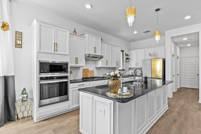1307 Wheelwright Dr, Forney, TX 75126 - kitchen featuring appliances with stainless steel finishes, light wood-type flooring, under cabinet range hood, white cabinets, and recessed lighting