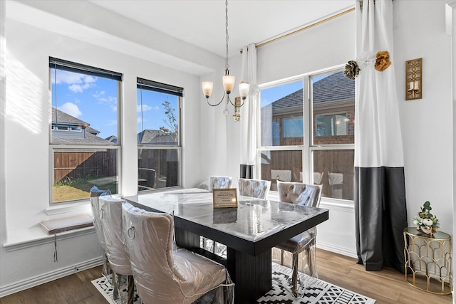 dining area with hardwood / wood-style flooring and a notable chandelier