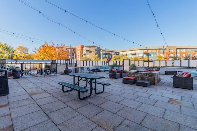 view of patio with an outdoor living space with a fire pit